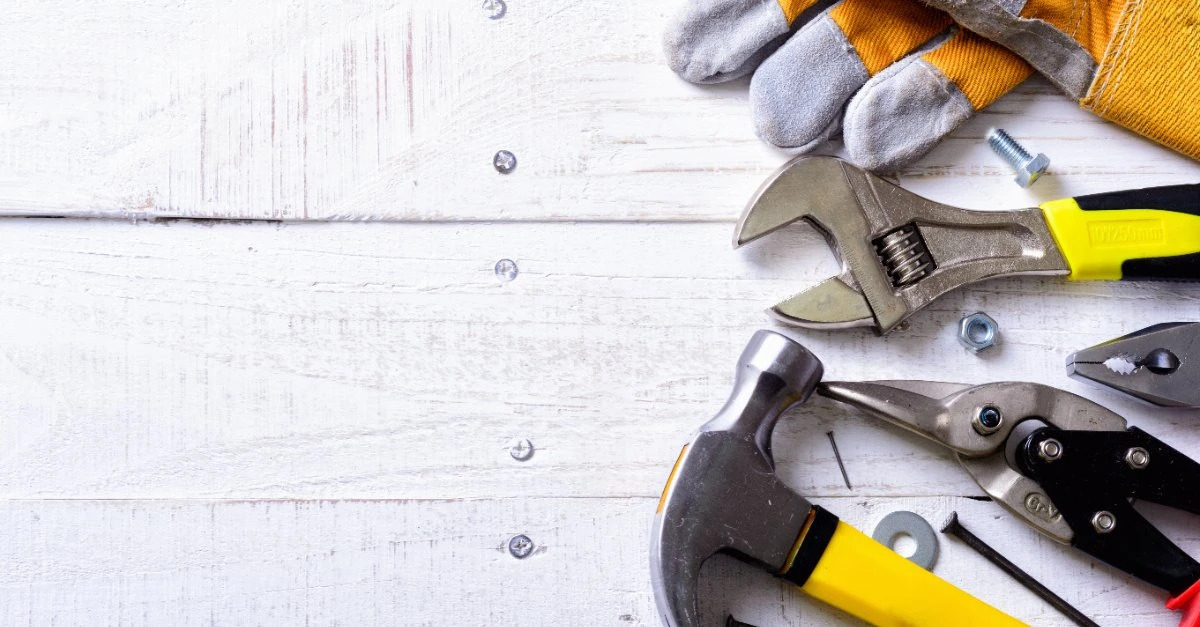 A collection of tools laid out on a white, wooden surface before being used by a handyman in Braintree, MA