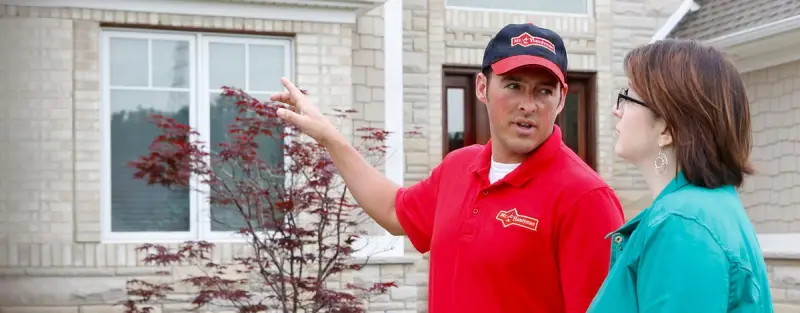 A Mustang handyman discussing home repairs with a customer.