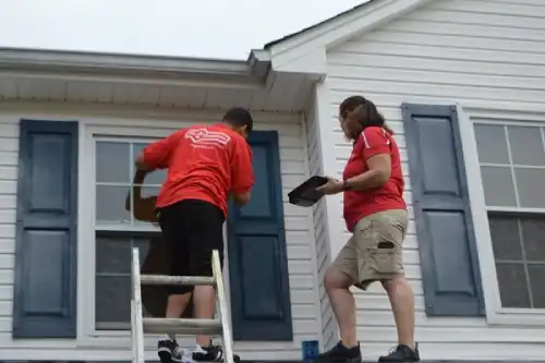 Two Mr. Handyman technicians installing second-floor window.