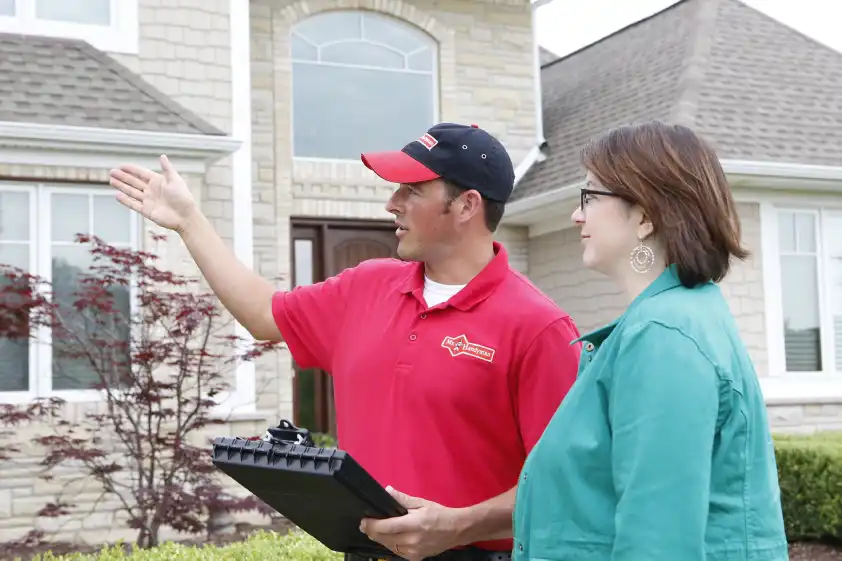 Mr. Handyman technician explaining siding repair service process to homeowner in Charleston