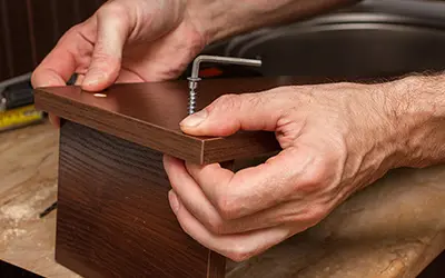 A Mr. Handyman technician assembling a piece of furniture.