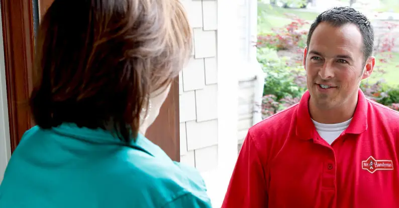 A handyman from Mr. Handyman speaking with a woman about her needs for stair repair services.