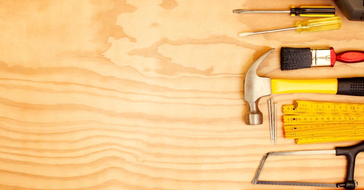 A wooden surface with several tools lying on top that might be used by a professional handyman, Warrenton VA.