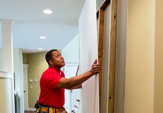 Mr. Handyman technician hanging drywall