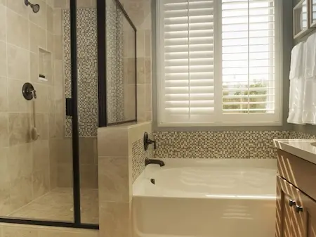 bathtub with shower stall in bathroom