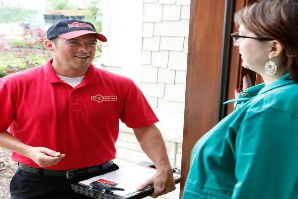 Mr. Handyman technician at door of Keller homeowner to perform drywall repairs.