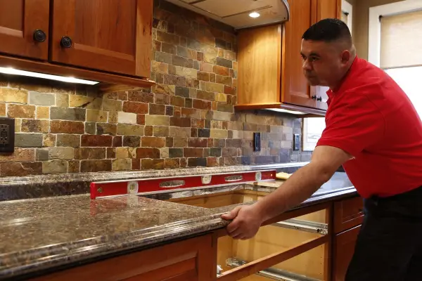  Mr. Handyman technician installing new granite countertops during kitchen remodel in Keller