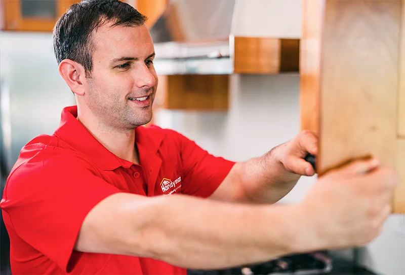 Mr. Handyman technician installing custom cabinets.