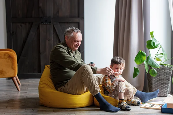 Grandfather enjoying with his grandson in a modern living room. A barn door can be seen in the background.