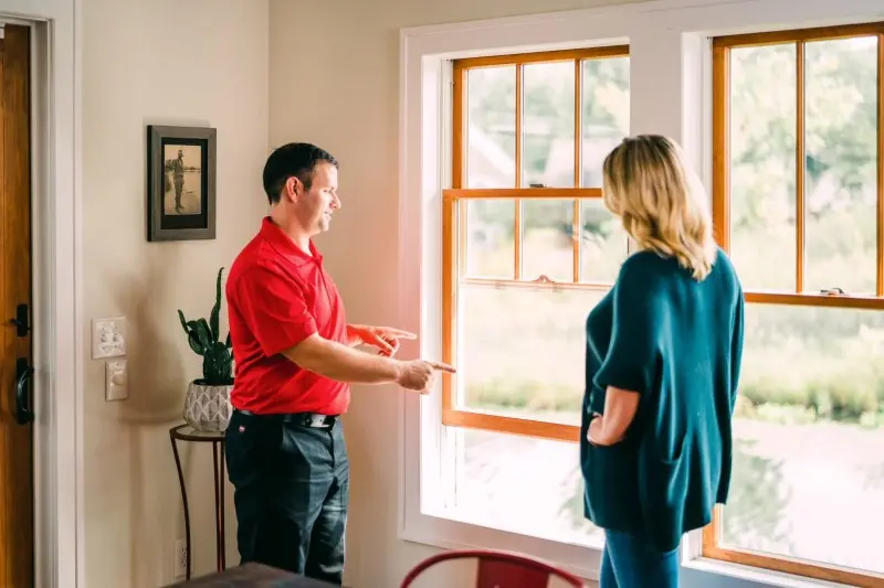 Mr. Handyman going over hanging blinds, curtains, or drapes with customer.