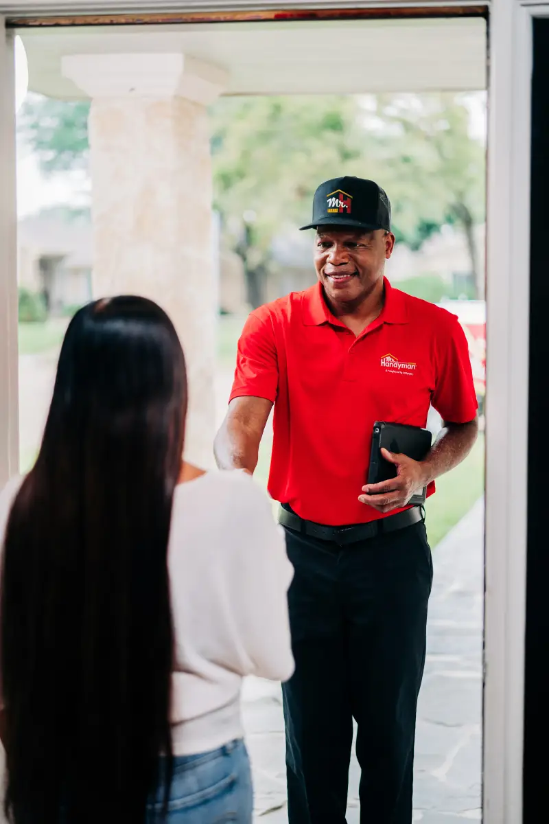 A Mr. Handyman technician speaking with a client.