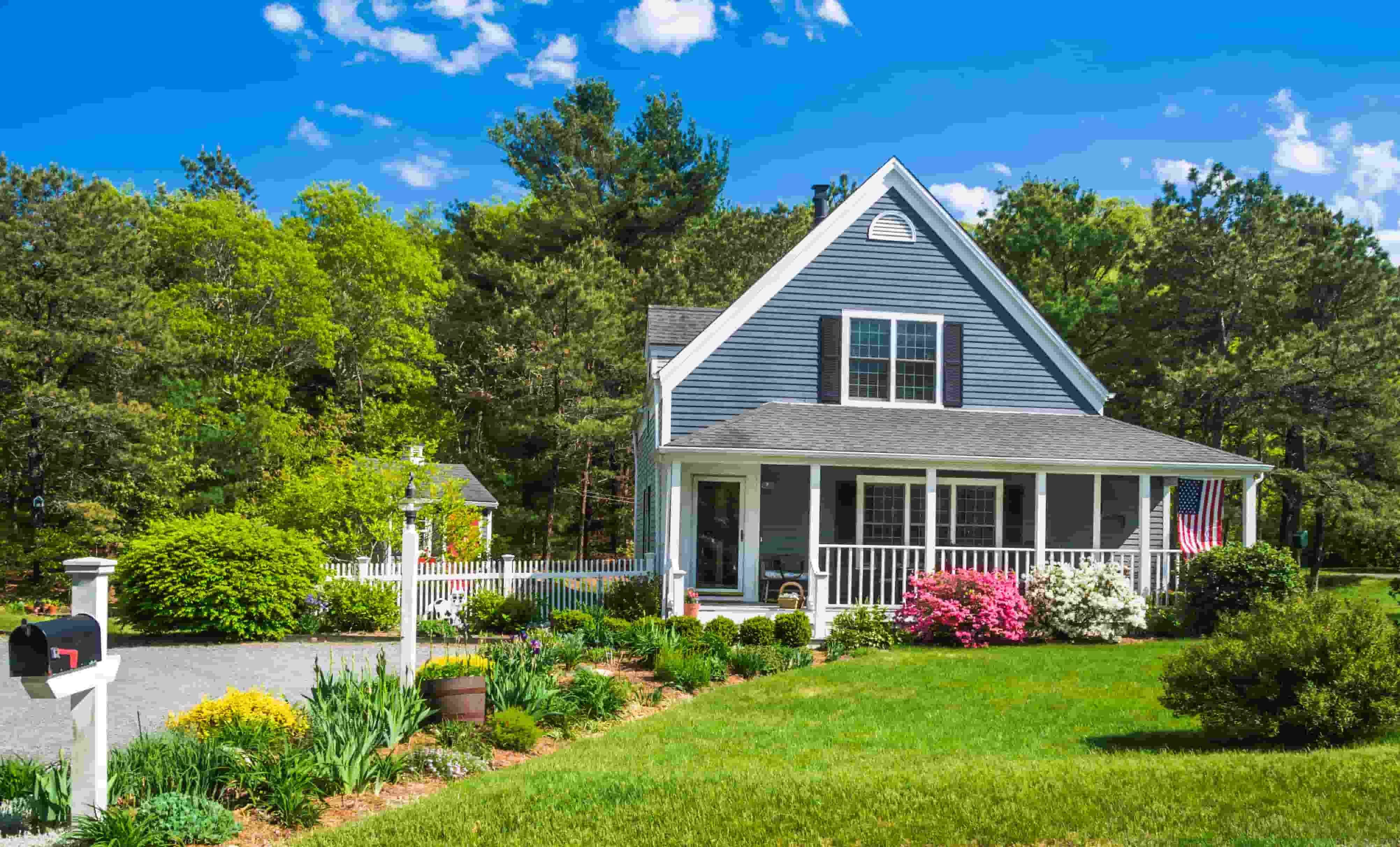 A house with a white picket fence and a lawn.