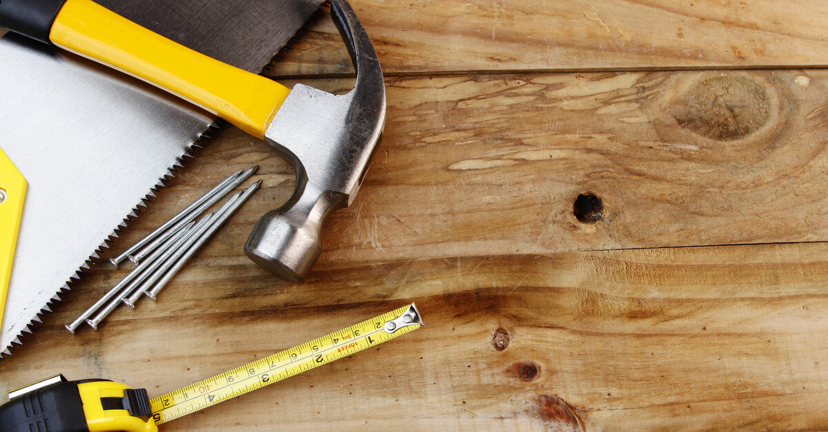 A hammer and nails on a wood surface.