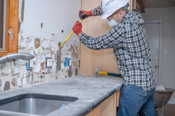 Renovation Worker Removing Kitchen Wall Tile.